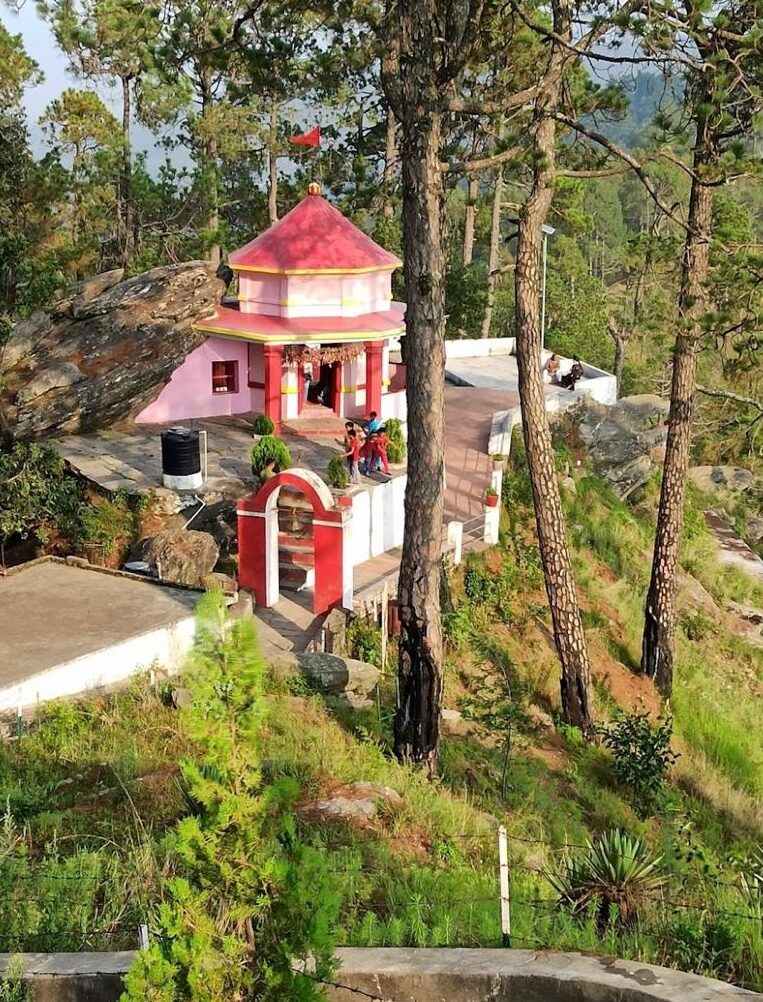 The temple is perched on a hilltop, providing stunning panoramic views of the surrounding Himalayan ranges.